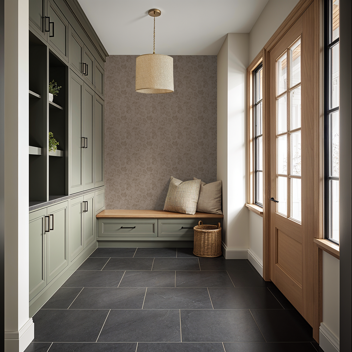 Sepia leaf pattern wallpaper in cozy mudroom with green cabinets and bench.