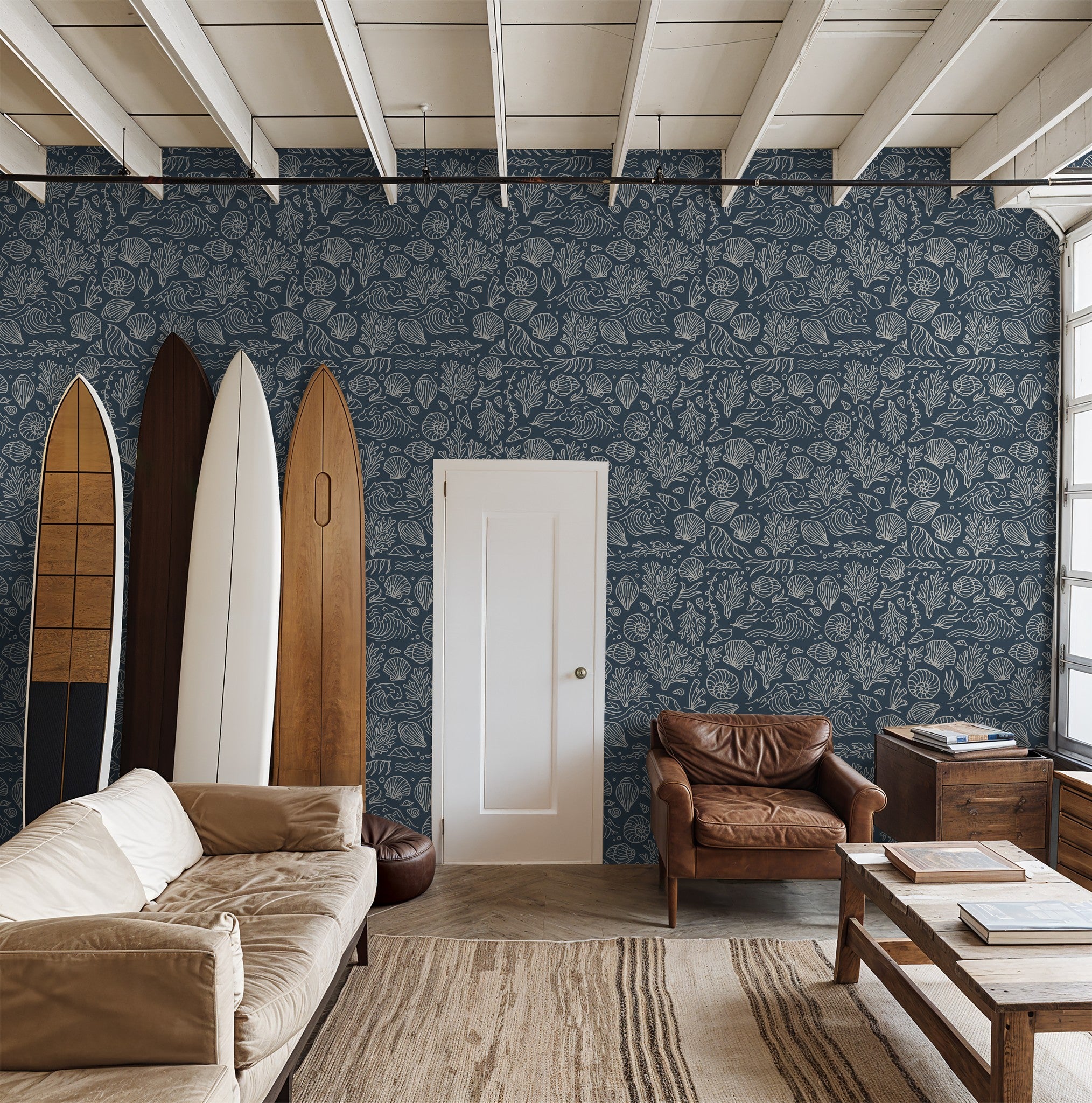 Coastal living room with slate blue shell and coral patterned wallpaper.