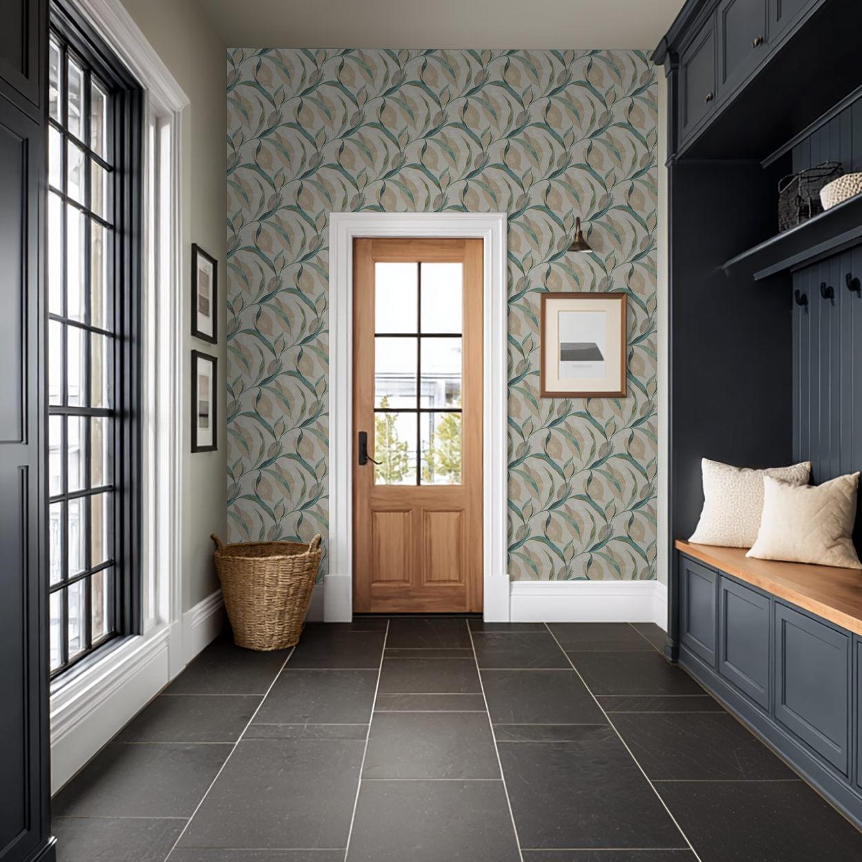 Teal and beige leaf pattern wallpaper in elegant entryway with wooden door and dark cabinets.