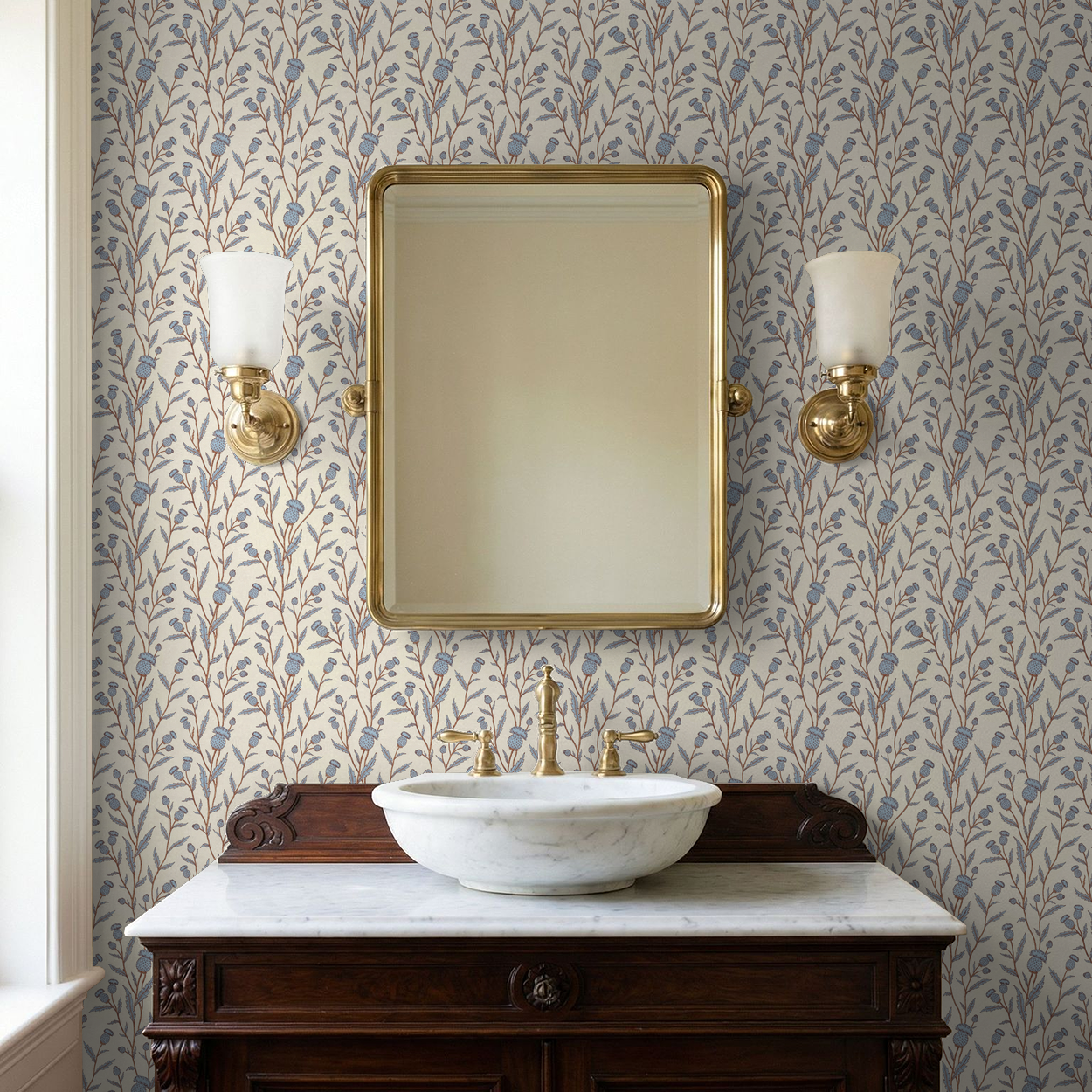 Thistle motif wallpaper in blue and brown in a vintage bathroom with mirror and sconces.