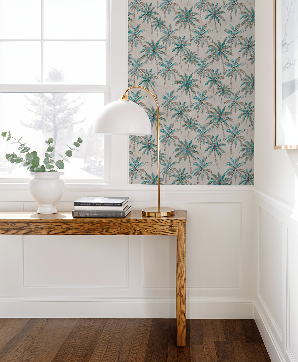 Tropical palm tree wallpaper in turquoise and brown in a sunlit room with wood furniture.