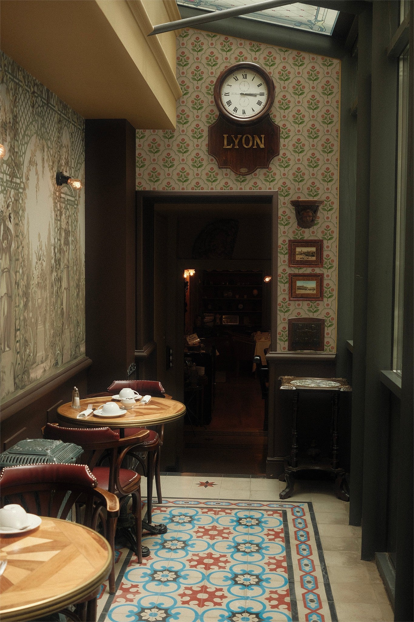 Vintage floral wallpaper with pink and green pattern in a cozy cafe setting.