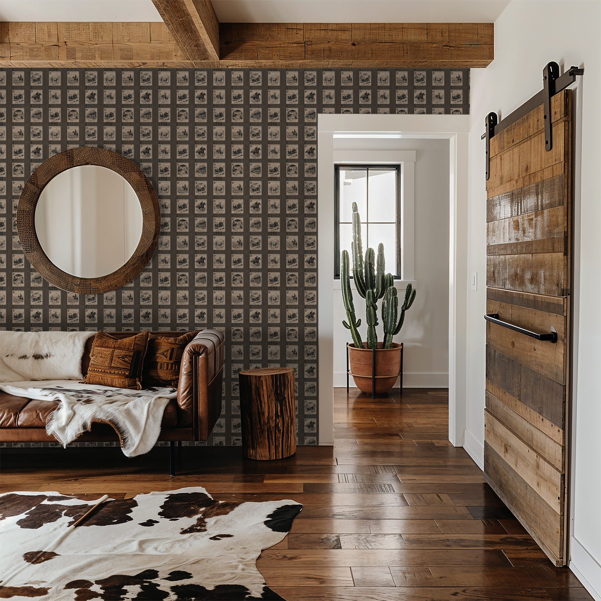 Vintage postage stamp wallpaper in rustic living room with leather sofa and cowhide rug.