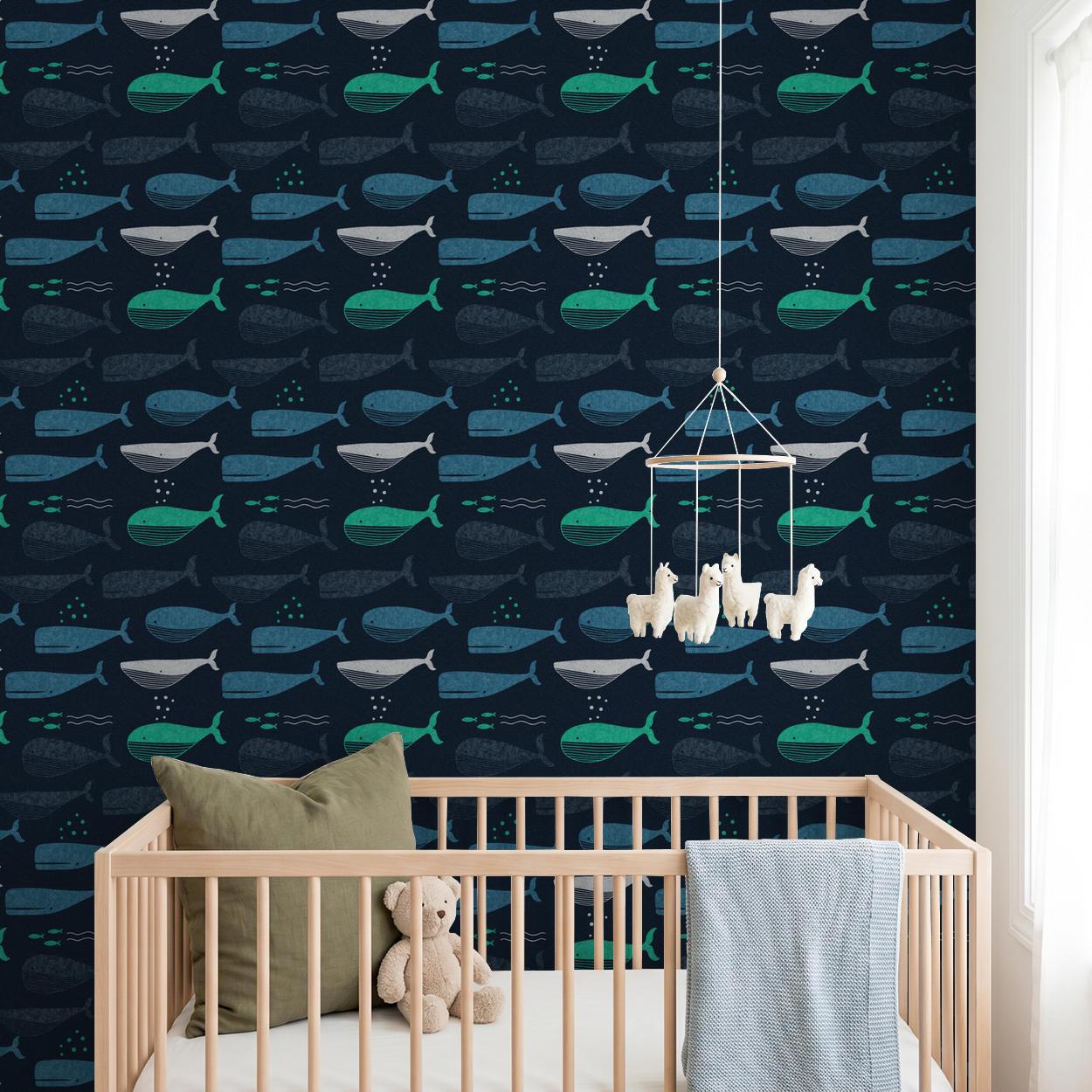 Navy wallpaper with teal and turquoise whale pattern in a nursery setting.